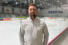 David Sattler standing in front of an ice rink.