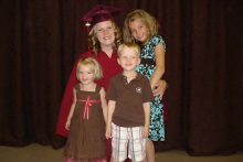 Krista Derksen posing with her kids at her graduation.