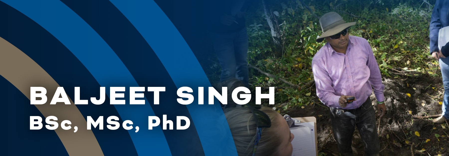 Dr. Baljeet Singh standing in a small dirt pit and talking to students.