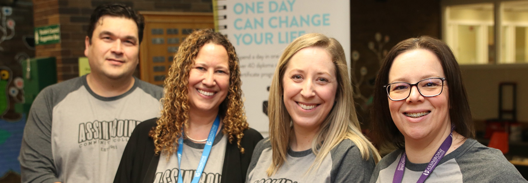 Four staff members standing next to each other, smiling at the camera.