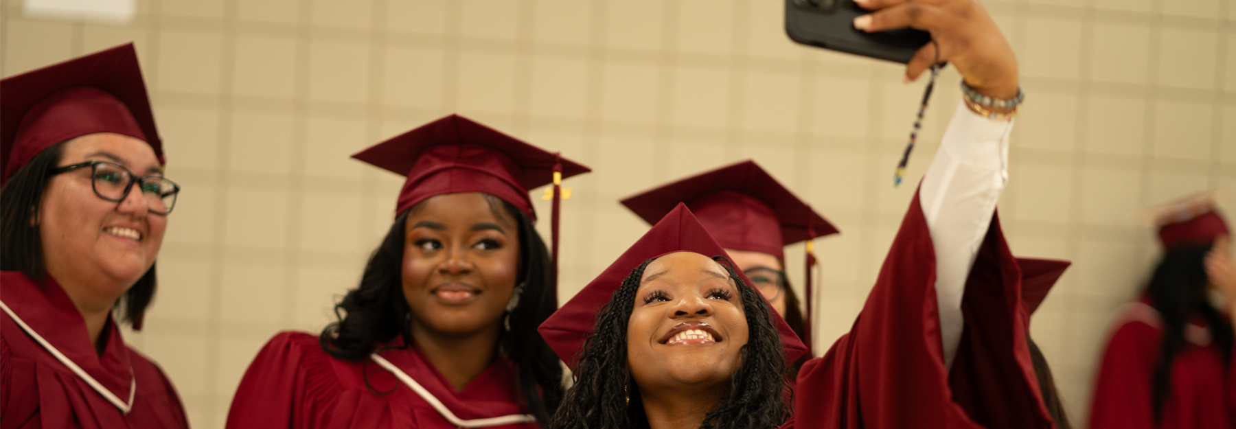 Students at graduation taking a selfie.