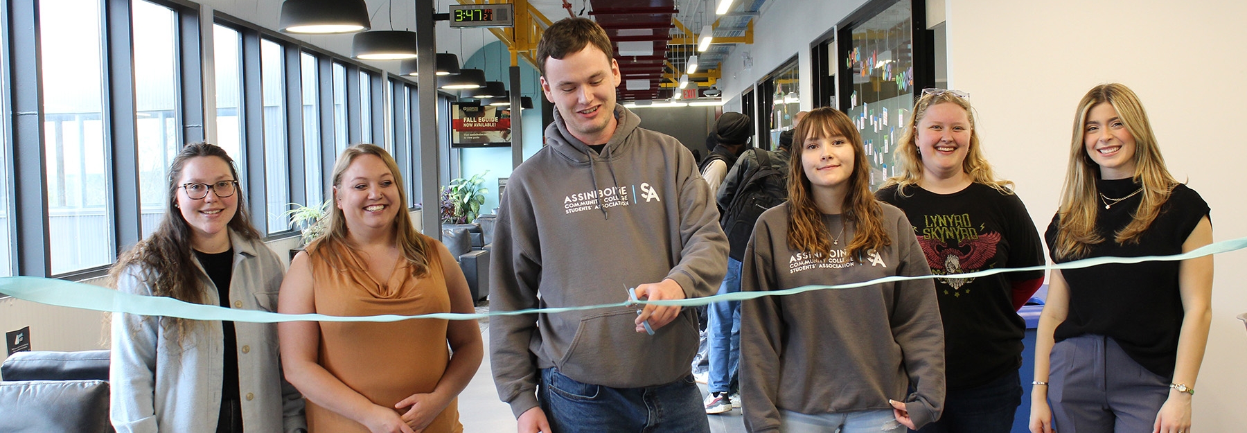 Six people from the students association standing in the newly renovated crossroads area during the grand opening.