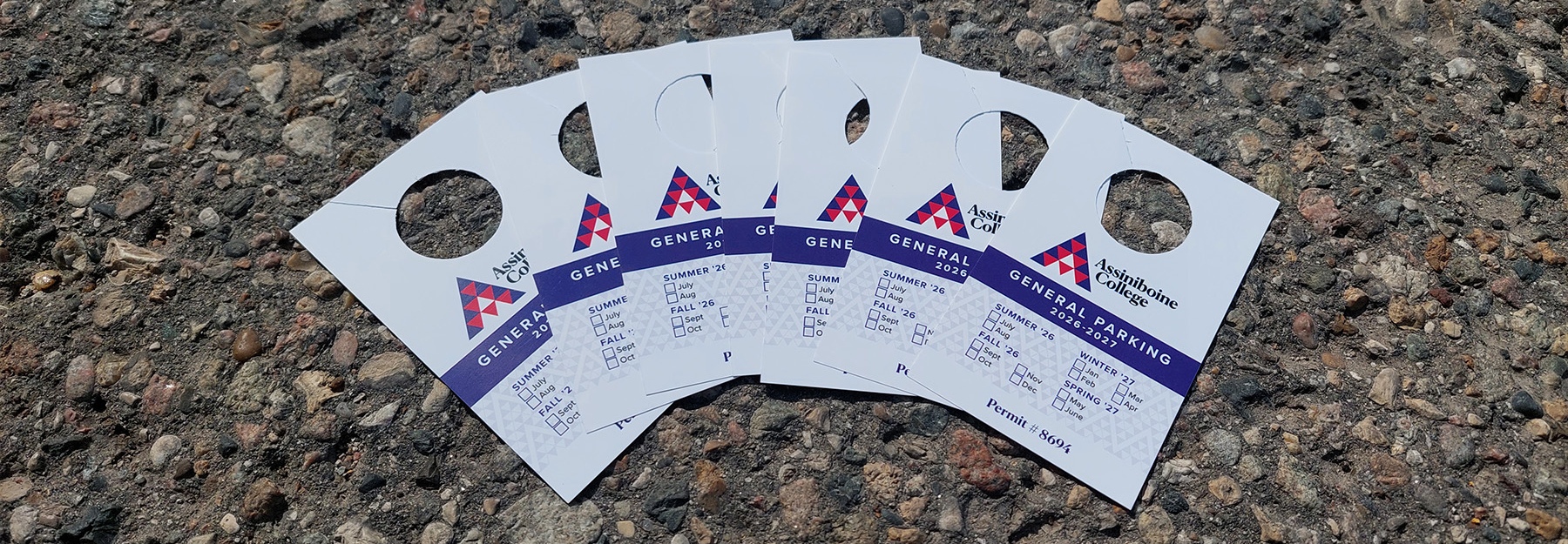 A stack of Parking Permits laid out on the asphalt.